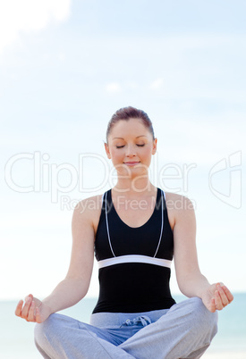 woman doing yoga sitting on the beach