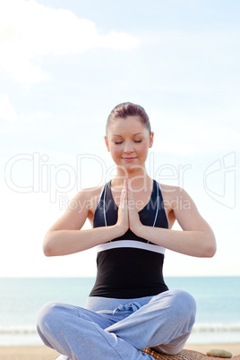 woman doing yoga sitting on the beach