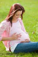 pregnant woman sitting on the grass