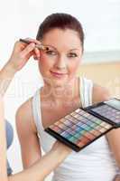 Make-up artist putting eye-shadow on woman