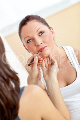 Young woman making-up her friend