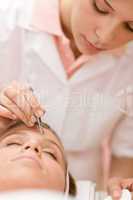 Woman remove eyebrows by tweezers