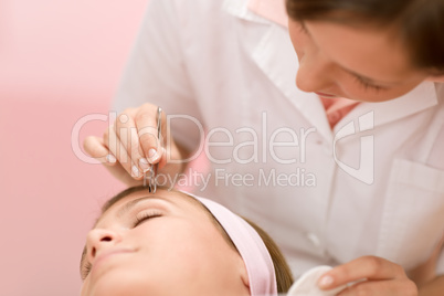 Using tweezers - woman having facial