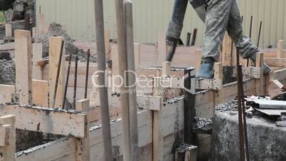 Worker pours the foundation of building