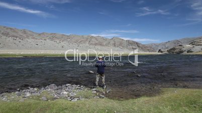 Fisherman with spinning catching fish in Khovd river