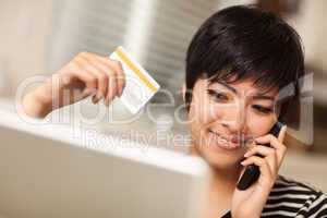 Multiethnic Woman Holding Phone and Credit Card Using Laptop