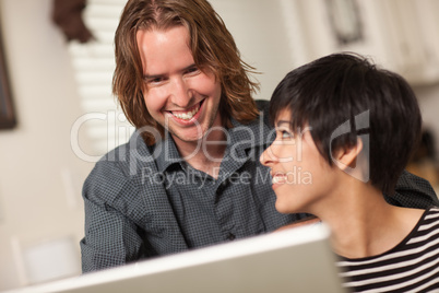 Happy Young Man and Woman Using Laptop Together