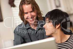 Happy Young Man and Woman Using Laptop Together
