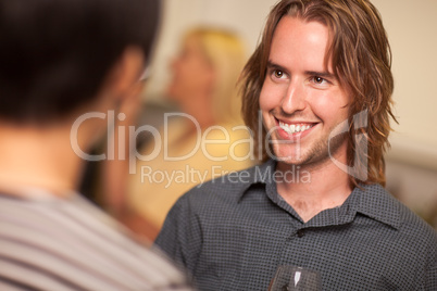 Smiling Young Man with Glass of Wine Socializing