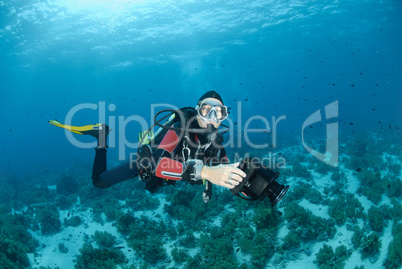 Female scuba diver and underwater video equipment.