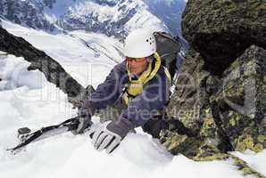 Mountaineer using an ice axe to climb a steep slope