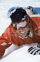 Young snowboarder lying in the snow