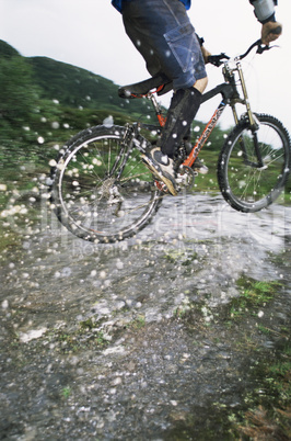 Mountain biker jumping over stream