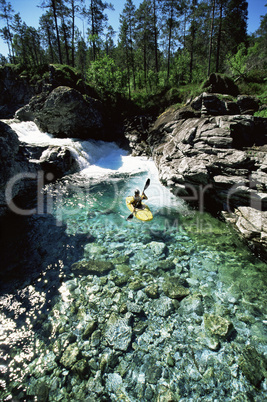 Young man kayaking in river