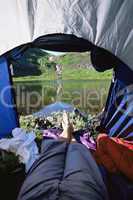 Woman lying in tent with a view of lake