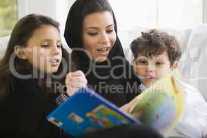A Middle Eastern family reading a book together