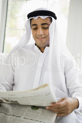 A Middle Eastern man reading a newspaper