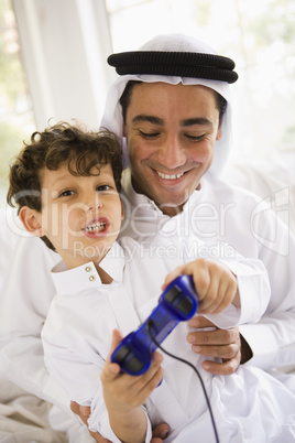 A Middle Eastern father and son playing a video game together