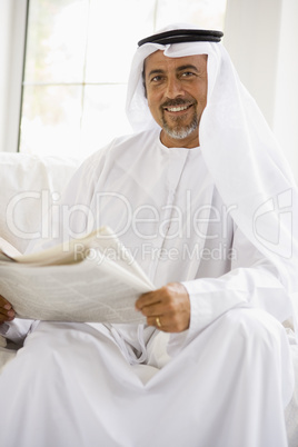 A Middle Eastern man reading a newspaper