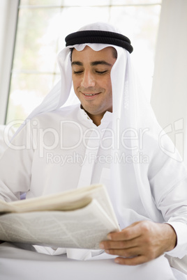 A Middle Eastern man reading a newspaper