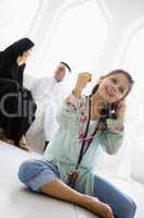 A Middle Eastern girl listening to a mp3 player