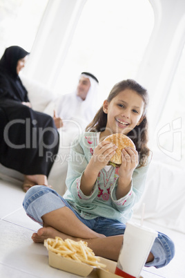 A Middle Eastern girl enjoying a fast food burger meal