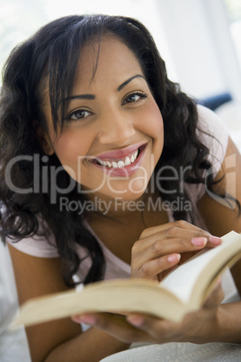 A Middle Eastern woman lying down reading