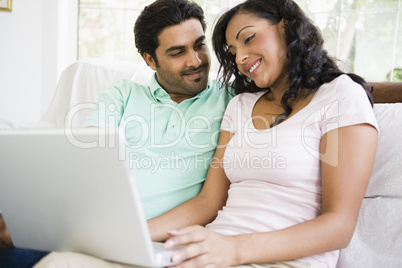 A Middle Eastern couple sitting with a laptop