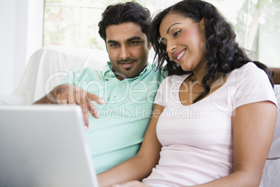 A Middle Eastern couple sitting with a laptop