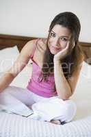 A Middle Eastern woman sitting on a bed