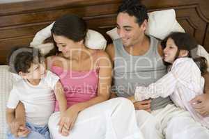 A Middle Eastern family lying on a bed