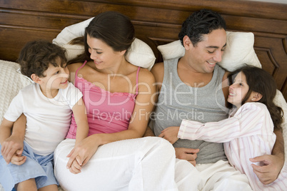 A Middle Eastern family lying on a bed
