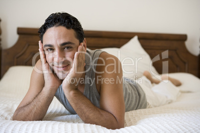 A Middle Eastern man lying on a bed