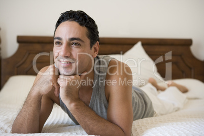 A Middle Eastern man lying on a bed