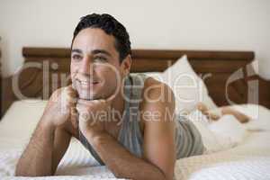 A Middle Eastern man lying on a bed