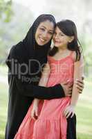 A Middle Eastern woman and her daughter sitting in a park