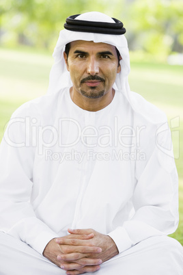 A Middle Eastern man sitting in a park