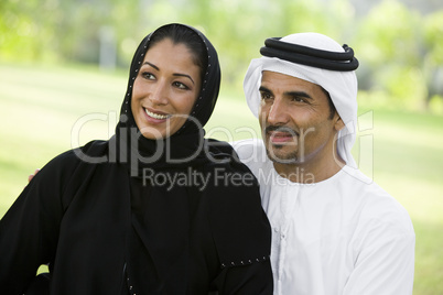 A Middle Eastern couple sitting in a park