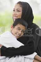 A Middle Eastern woman and her son sitting in a park