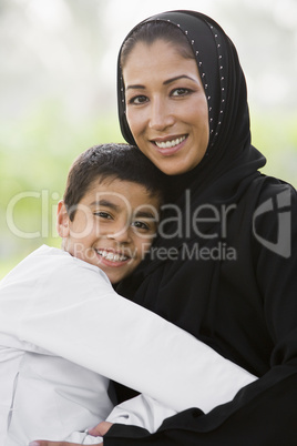 A Middle Eastern woman and her son sitting in a park