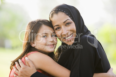 A Middle Eastern woman and her daughter sitting in a park