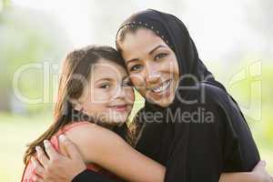 A Middle Eastern woman and her daughter sitting in a park