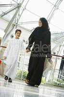 A Middle Eastern woman and her son in a shopping mall