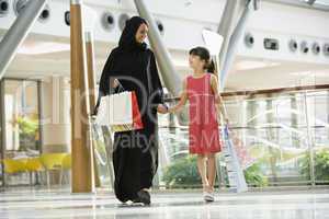 A Middle Eastern woman with a girl in a shopping mall