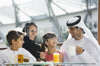 A Middle Eastern family enjoying a meal in a restaurant