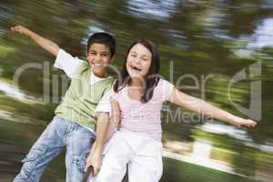 a boy and a firl having fun on a carrousel