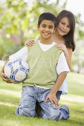 Ein Junge und ein Mädchen lachend auf einer Wiese