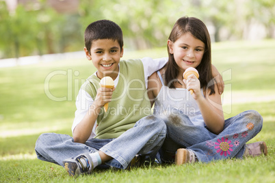 Ein Junge und ein Mädchen lachend auf einer Wiese