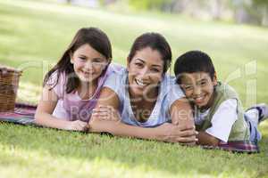 beautiful woman having picnic in the park with her kids