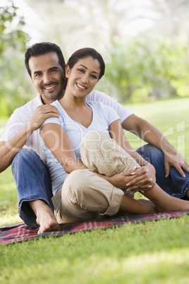 happy couple sitting in the park